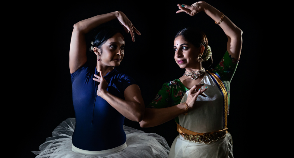 Two woman in dance poses, one in a tutu, the other in classical Indian dress. 