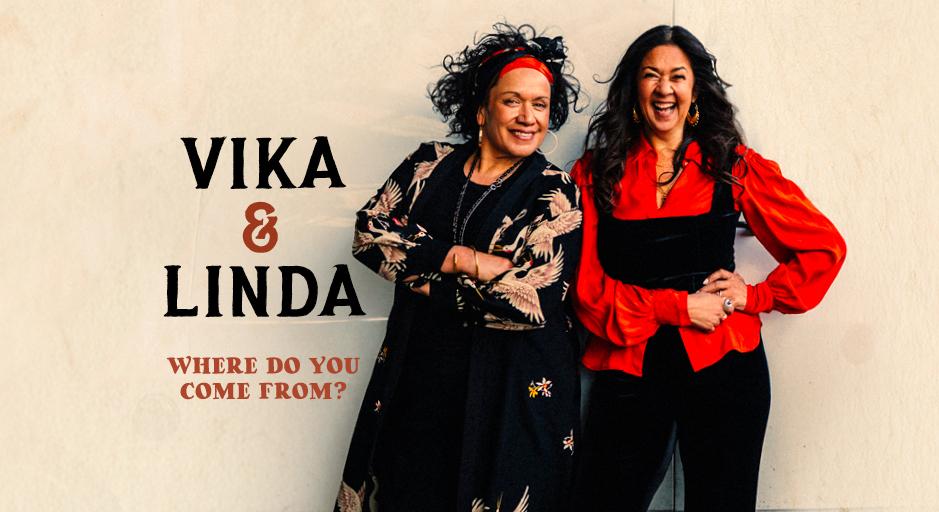 Vika and Linda smile in front of a wall