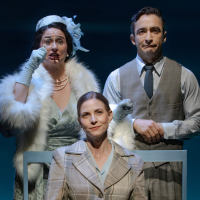 One woman sits on a chair while another woman stands behind, dressed in gloves and a hat, and a man in a tie and vest. 