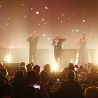 4 singers on stage in front of a crowd